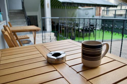 una taza de café y una rosquilla sobre una mesa de madera en Me & You Hostel en Tirana