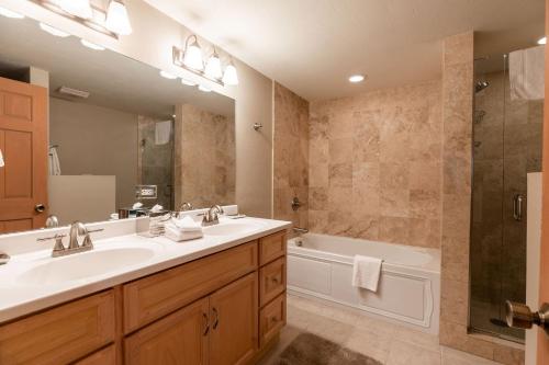a bathroom with a sink and a tub and a mirror at Villa Cortina by Vail Realty in Vail