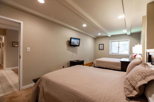 a bedroom with two beds and a tv on the wall at Villa Cortina by Vail Realty in Vail