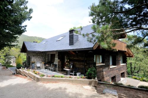a log house with a patio in front of it at Hotel Rural Las Rozuelas in Cercedilla