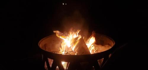 a fire in a bucket with flames in it at Chandler Hill Base Camp - Enjoy A Nature Getaway in this Rustic Home in the Mountains, 10 minutes from Sunday River Ski Mountain! home in Bethel