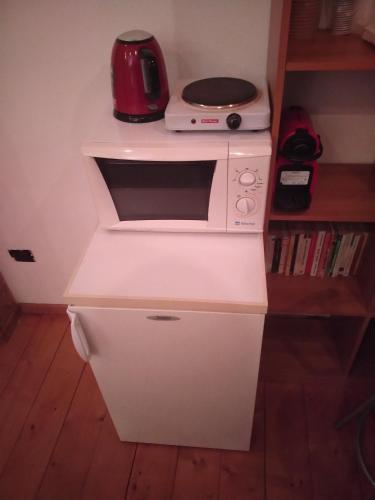 a white microwave sitting on top of a counter at La casa sull'arcobaleno in Manta
