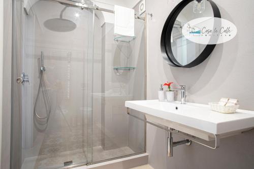 a white bathroom with a shower and a sink at Casa Le Calle in Positano