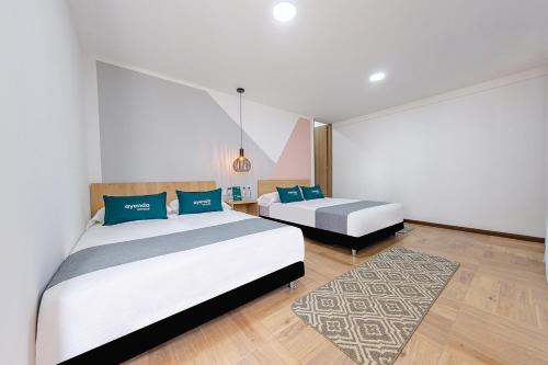 a bedroom with two beds and a rug at Ayenda De La Calle Real in Armenia