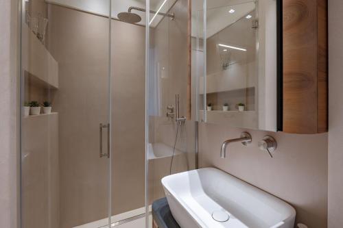 a bathroom with a sink and a glass shower at CHIANTI LUXURY APARTMENTS GREVE in Greve in Chianti