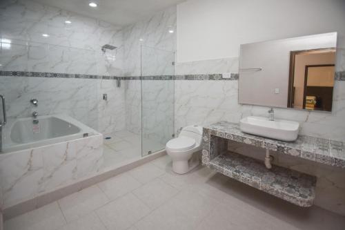 a bathroom with a tub and a toilet and a sink at HOTEL MI HERMOSO DOLORES in Dolores Hidalgo