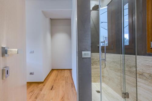 a glass shower in a room with a hallway at CHIANTI LUXURY APARTMENTS GREVE in Greve in Chianti