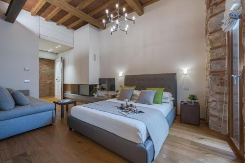 - une chambre avec un grand lit et un canapé bleu dans l'établissement CHIANTI LUXURY APARTMENTS GREVE, à Greve in Chianti