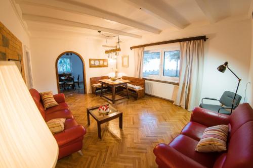 a living room with red couches and a table at Vila Park Ravne in Ravne na Koroškem