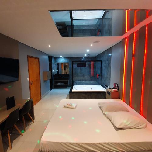 a bedroom with a large bed and a bathroom at Desejo Motel in Araçoiaba da Serra
