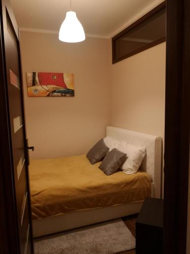 a bedroom with a bed with two pillows on it at Apartament Marzenie 13 - Opole in Opole