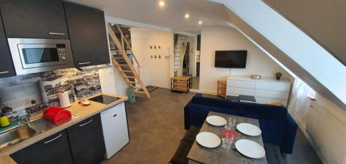 a kitchen and a living room with a table and chairs at Le Deauvillais - Appartement Plein Centre - 4 pers - 2 mn plage - Idéal Famille in Deauville