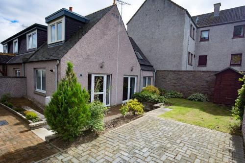 a house with a brick driveway in front of it at Bright House with Garden & Patio in Market Town in Inverurie