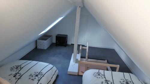 une chambre mansardée avec deux lits et une table dans l'établissement Le Deauvillais - Appartement Plein Centre - 4 pers - 2 mn plage - Idéal Famille, à Deauville