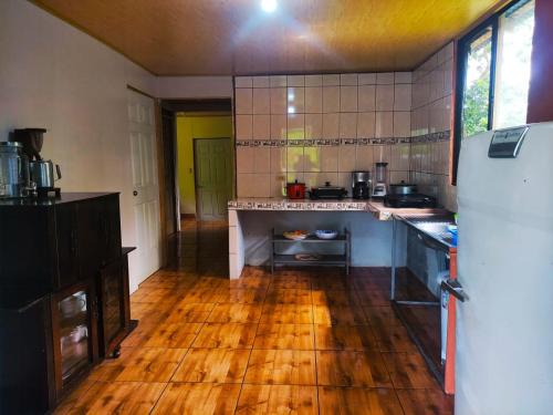 cocina con nevera y suelo de madera en Amphibia House, en Agua Azul