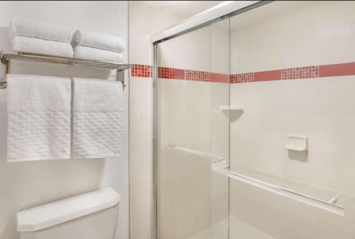 a bathroom with a shower, toilet and sink at Best Western Plus Raffles Inn & Suites in Anaheim