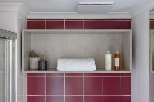 a bathroom with red and white tiles and a shelf at Hotel Hacienda in Sydney