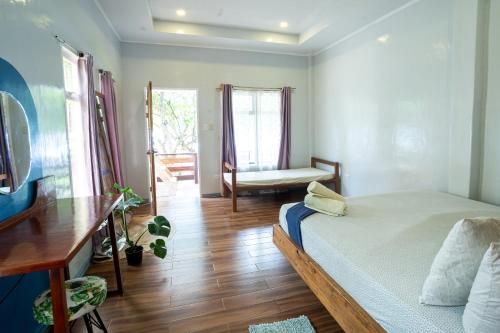 a bedroom with a bed and a desk and a chair at YAMA APARTMENTS - Private Beachfront in General Luna