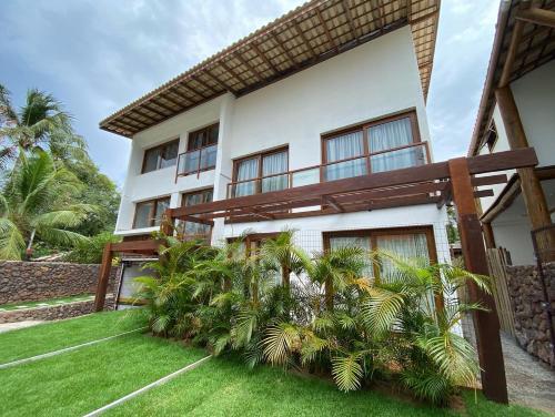 a house with a green lawn in front of it at Praia do Forte Ohana Residence in Praia do Forte