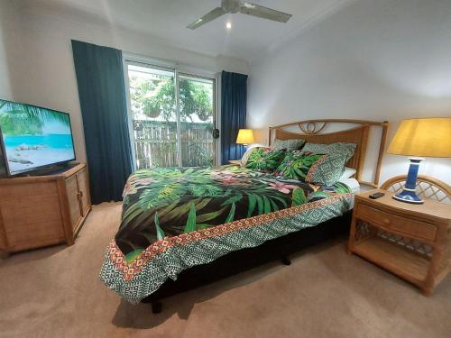 a bedroom with a bed and a flat screen tv at Hawaiian Escape on the Sunshine Coast, pet friendly in Alexandra Headland