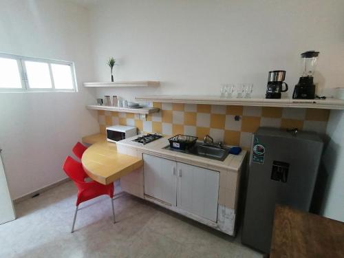 una pequeña cocina con mesa y nevera en Htl & Suites Neruda, ubicación, limpieza, facturamos en Colima