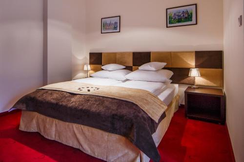 a bedroom with a large bed with white sheets and pillows at Boutique Hotel's II in Łódź