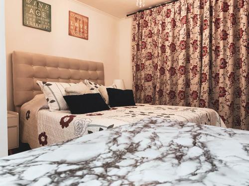 two beds in a bedroom with curtains and a bed sidx sidx sidx sidx at Depto Metro Cal y Canto (Estudio) in Santiago