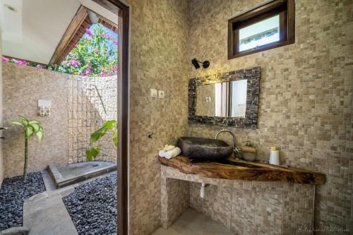 a bathroom with a sink and a mirror at Bunga Laut Bungalow in Amed