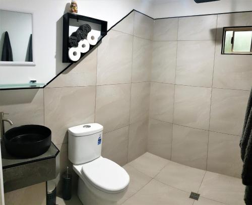 a bathroom with a toilet and a sink at Vista Hinchinbrook in Cardwell