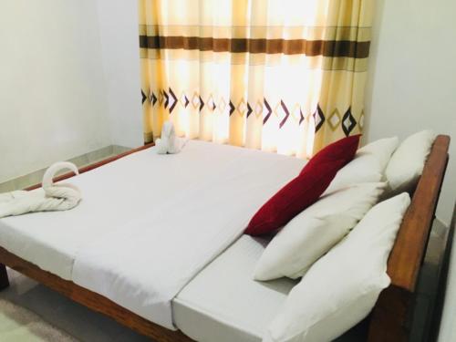 een bed in een kamer met een gordijn bij Adisham village home in Haputale