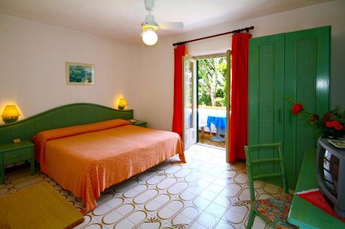 - une chambre avec un lit et une télévision dans l'établissement Hotel Park Calitto, à Ischia