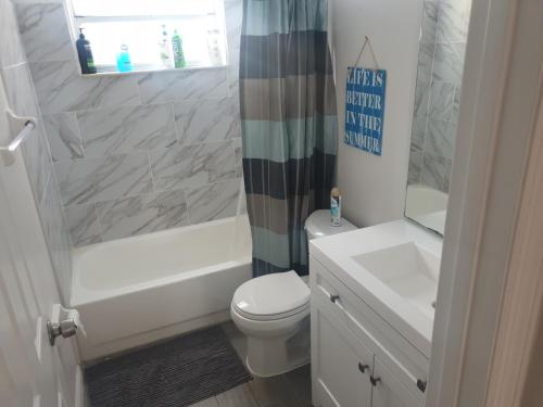 La salle de bains est pourvue de toilettes, d'une baignoire et d'un lavabo. dans l'établissement Somerset Villas 84, à Kissimmee