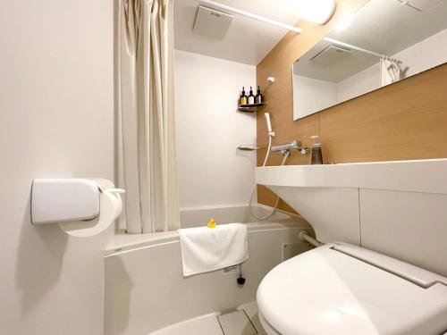 a white bathroom with a toilet and a sink at H.B.P HOTEL in Osaka