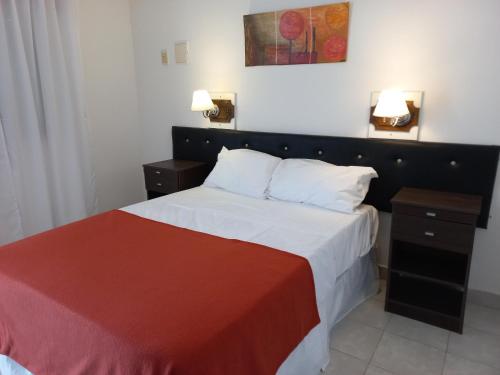 1 dormitorio con 1 cama con manta roja y blanca en Ayres del Rio en Formosa