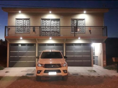 een auto geparkeerd voor een huis met twee garagedeuren bij Nijulu in Malargüe