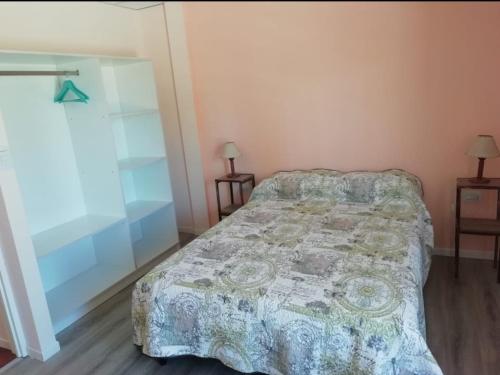 een slaapkamer met een bed, 2 lampen en een raam bij Nijulu in Malargüe