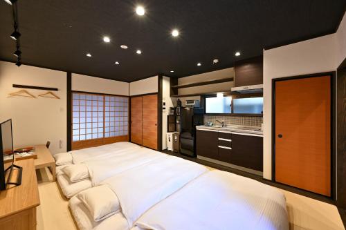 une grande chambre avec un grand lit et une cuisine dans l'établissement 行灯離れ京都五条 Andon Hanare Kyoto Gojo, à Kyoto