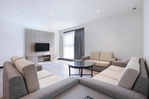a living room with a couch and a tv at SITARA HOTEL APARTMENT in Dubai