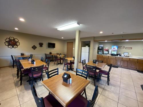 a restaurant with wooden tables and chairs and a counter at Green Gables Inn in Branson