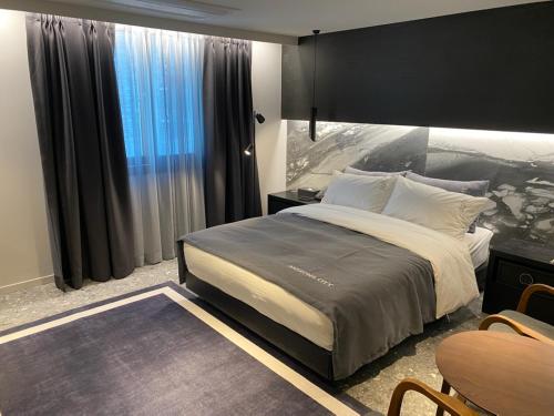 a bedroom with a large bed and a large window at Anseong City Hotel in Anseong