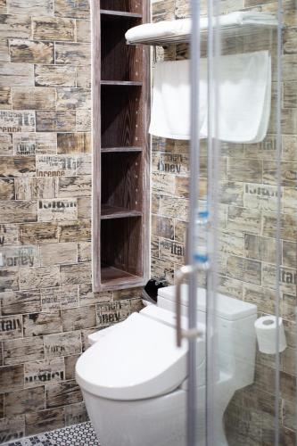 a bathroom with a toilet and a glass shower at R&J Guesthouse in Yuanshan