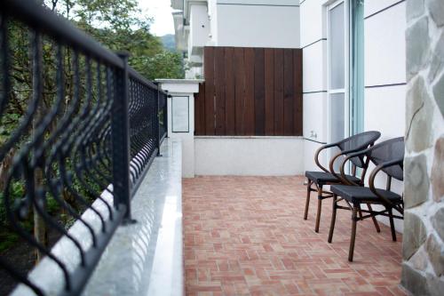 a balcony with a row of chairs and a fence at R&J Guesthouse in Yuanshan