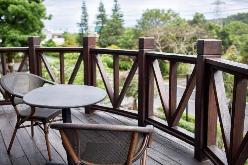 a table and two chairs and a table on a balcony at R&J Guesthouse in Yuanshan