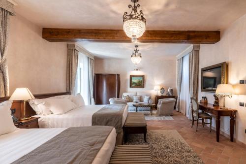 a bedroom with two beds and a living room at Villa Petriolo - Small Luxury Hotels of the World in Cerreto Guidi