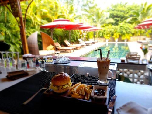 a tray of food on a table with a sandwich and french fries at Sahaa Beach Resort in Sihanoukville