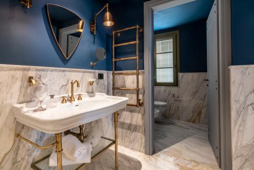 a bathroom with a sink and a toilet at Villa Petriolo - Small Luxury Hotels of the World in Cerreto Guidi