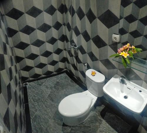 a bathroom with a white toilet and a sink at Rion Hostel Bogor in Bogor