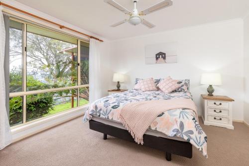 a bedroom with a bed and a window at Lakeview on Victoria in Forster