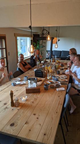 un gruppo di persone seduti intorno a un grande tavolo di legno di Japan Snowsports a Iiyama