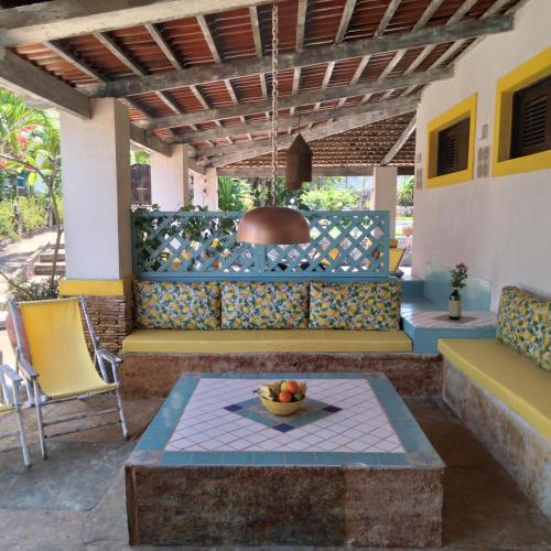 a patio with a couch and a bowl of fruit on a table at Barbanera Club & Hotel de Charme in Caucaia